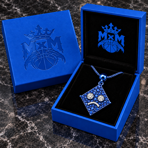 MxM Blue diamond-eye sad face pendant concept, matching MxM-logo luxury box on black marble tabletop.