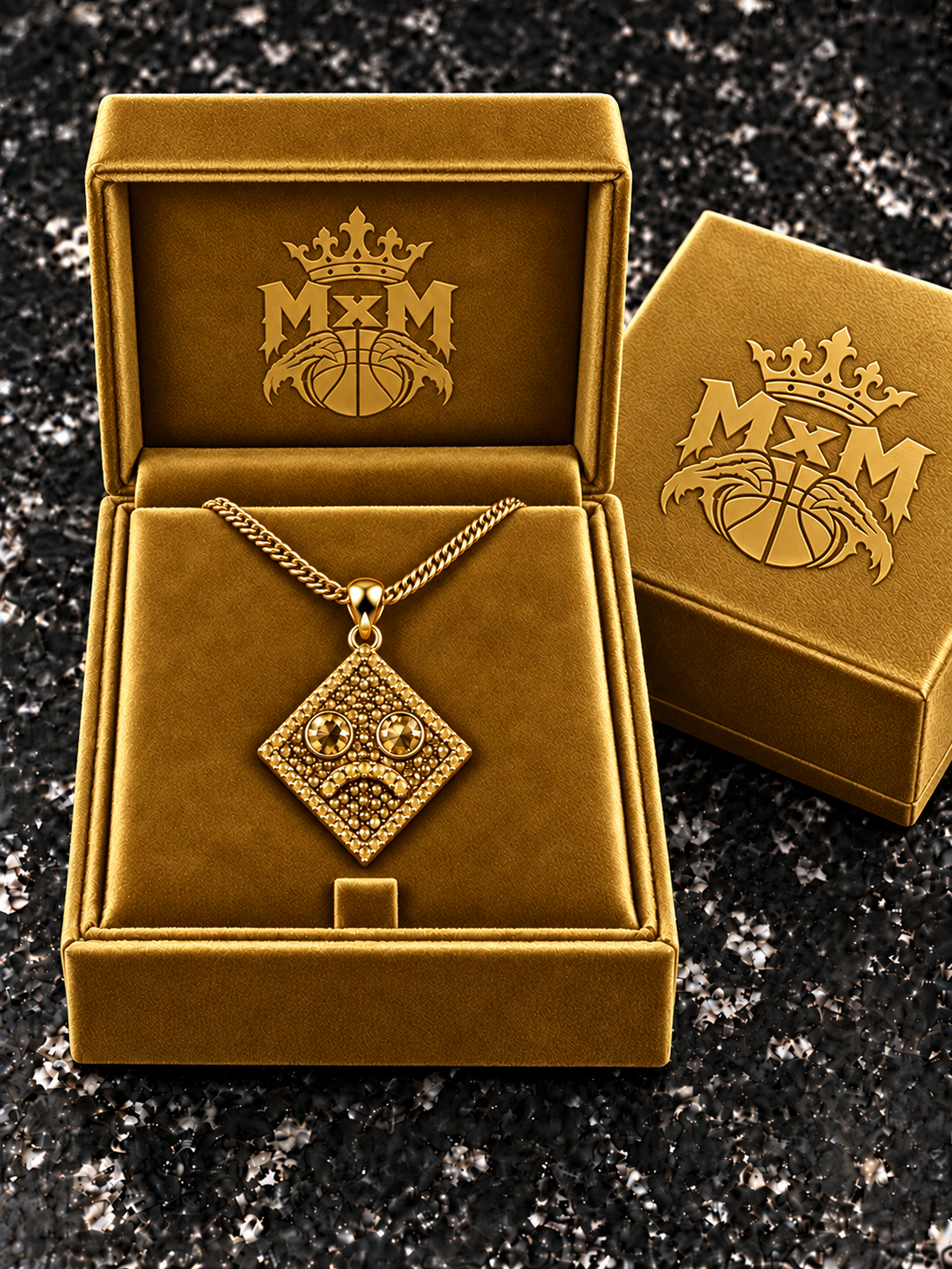 Gold MxM sad-face necklace in matching velvet box with crests inside and outside