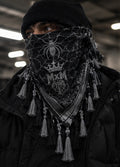 MxM black and grey spiderweb keffiyeh on a model with prominent spider face motif, crowned MxM basketball logo and thin knotted tassels. Digital design preview, not a manufactured sample photo.