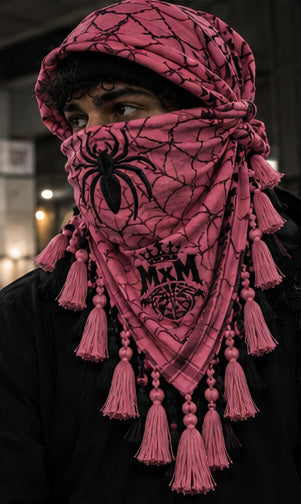 MxM burgundy rose keffiyeh on a model with spider face, web pattern, crowned MxM emblem and hanging tassels. Digital preorder design mockup, not a physical sample photo.