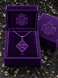 Purple MxM sad-face necklace in matching velvet box with crests inside and outside