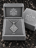 Silver MxM sad-face necklace in matching velvet box with crests inside and outside