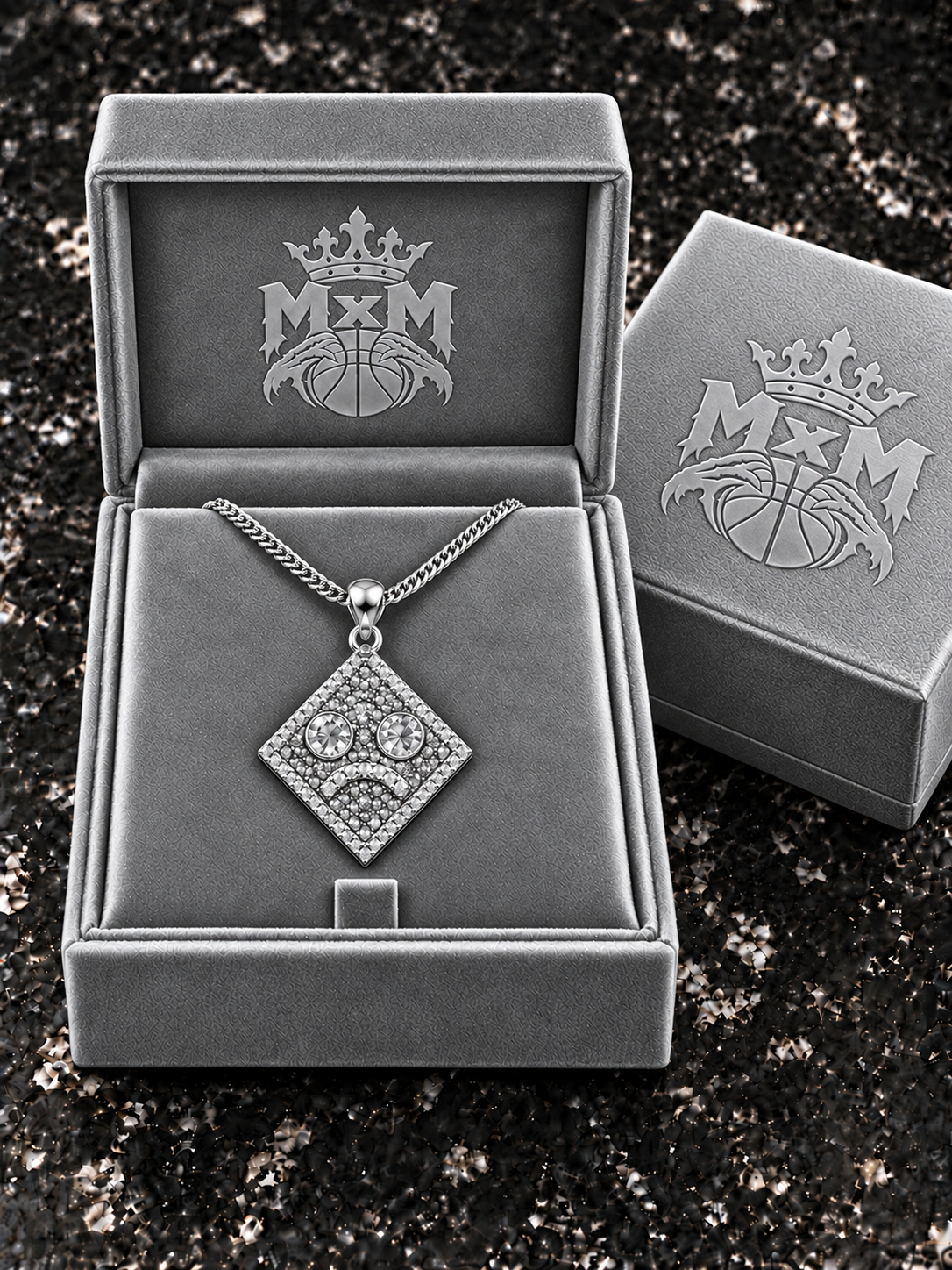 Silver MxM sad-face necklace in matching velvet box with crests inside and outside