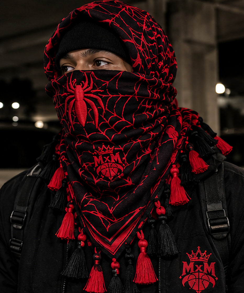Black and red MxM spider-web keffiyah hood and mask modeled with embroidered web details and tassels. Concept visualization, not a manufactured sample photograph.